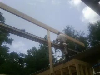 Carpenter setting a ridge beam over a new addition frame — Ice Dam Removal by Roofing Brothers in Narberth