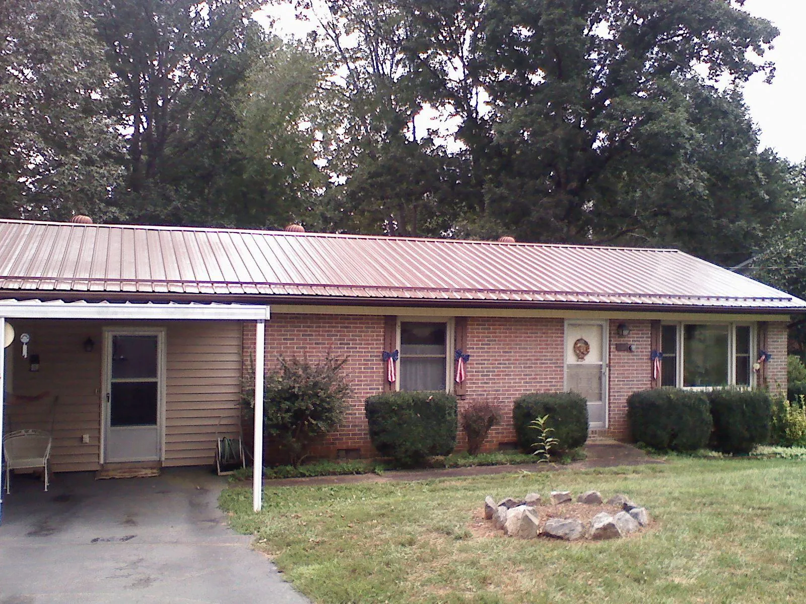 Bronze metal roof and carport on a brick ranch home — Roof Repair work by our crew in Narberth